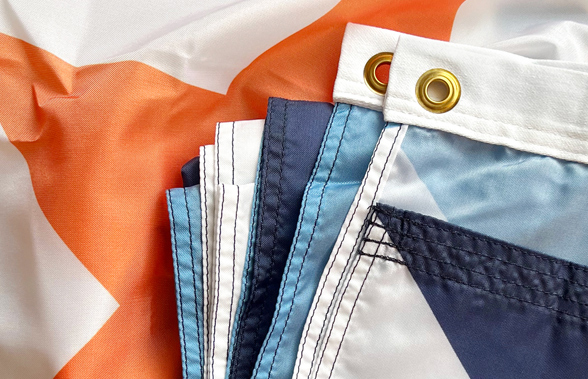 Close-up of the folded Syracuse city flag showing its stitched seams and brass grommets.